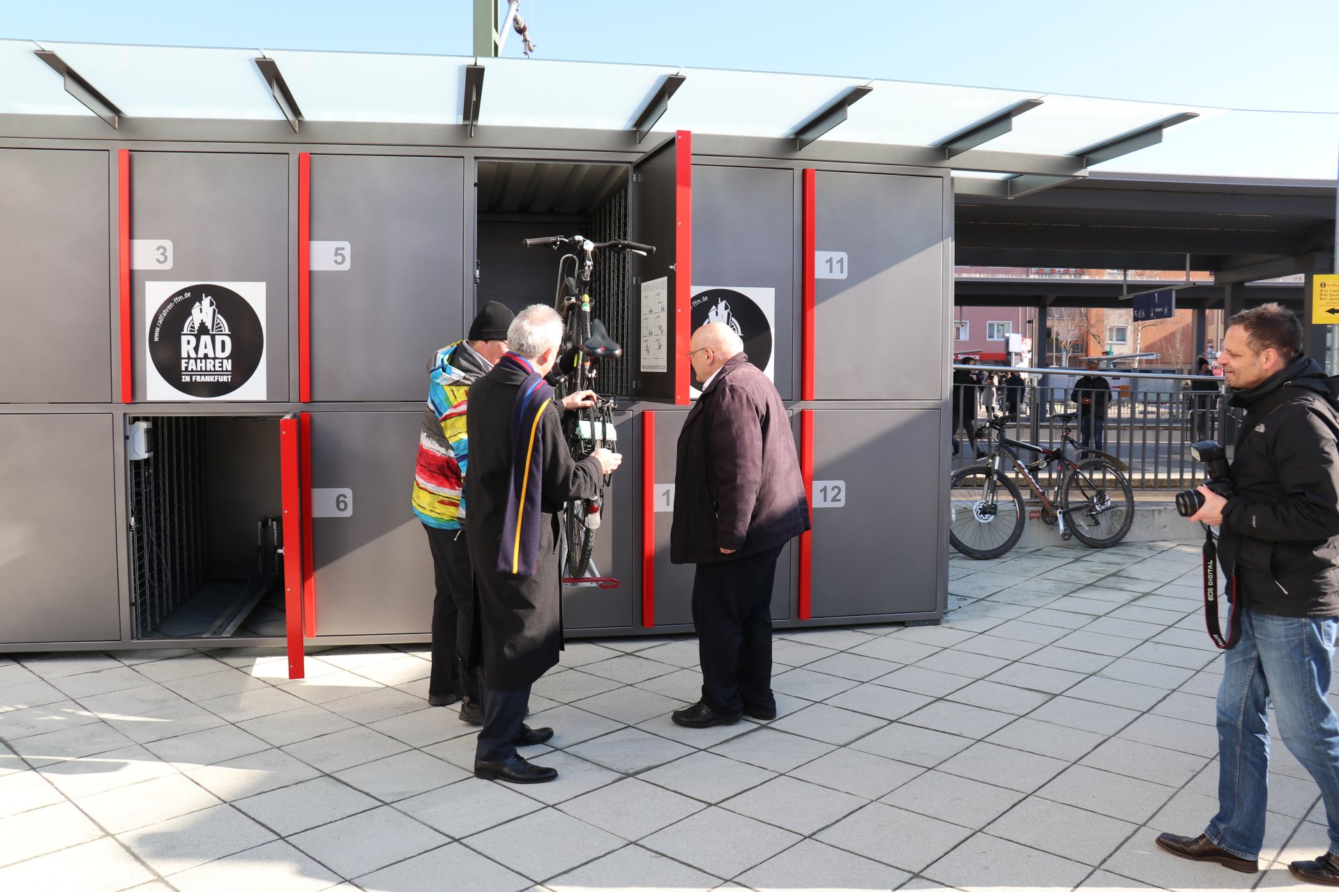 Oberbürgermeister Peter Feldmann, ADFC-Sprecher Bertram Giebeler und Verkehrsdezernent Klaus Oesterling probieren die neuen abschließbaren Fahrradboxen als erste aus